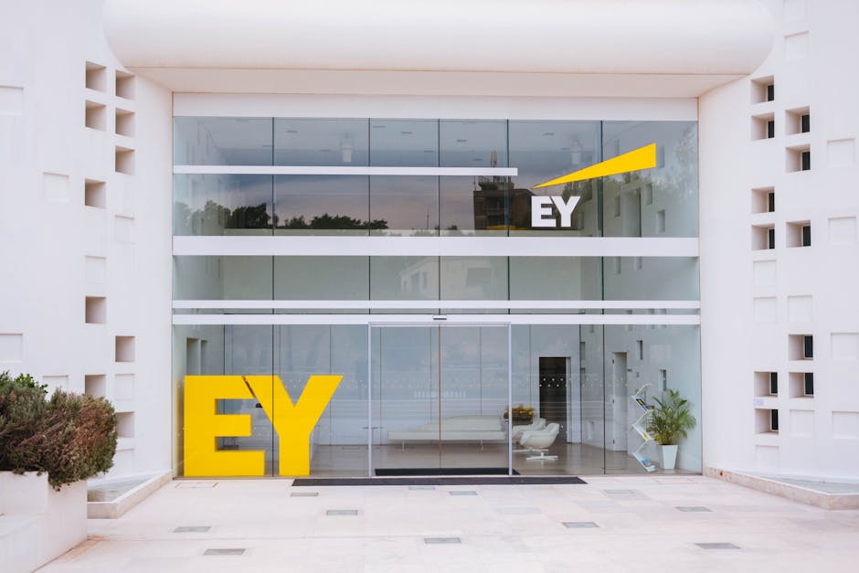 Exterior view of a corporate building entrance with EY logo and minimalist design