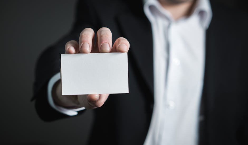 A man in a suit presenting a blank business card for corporate usage